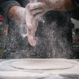 a man shakes flour from his hands